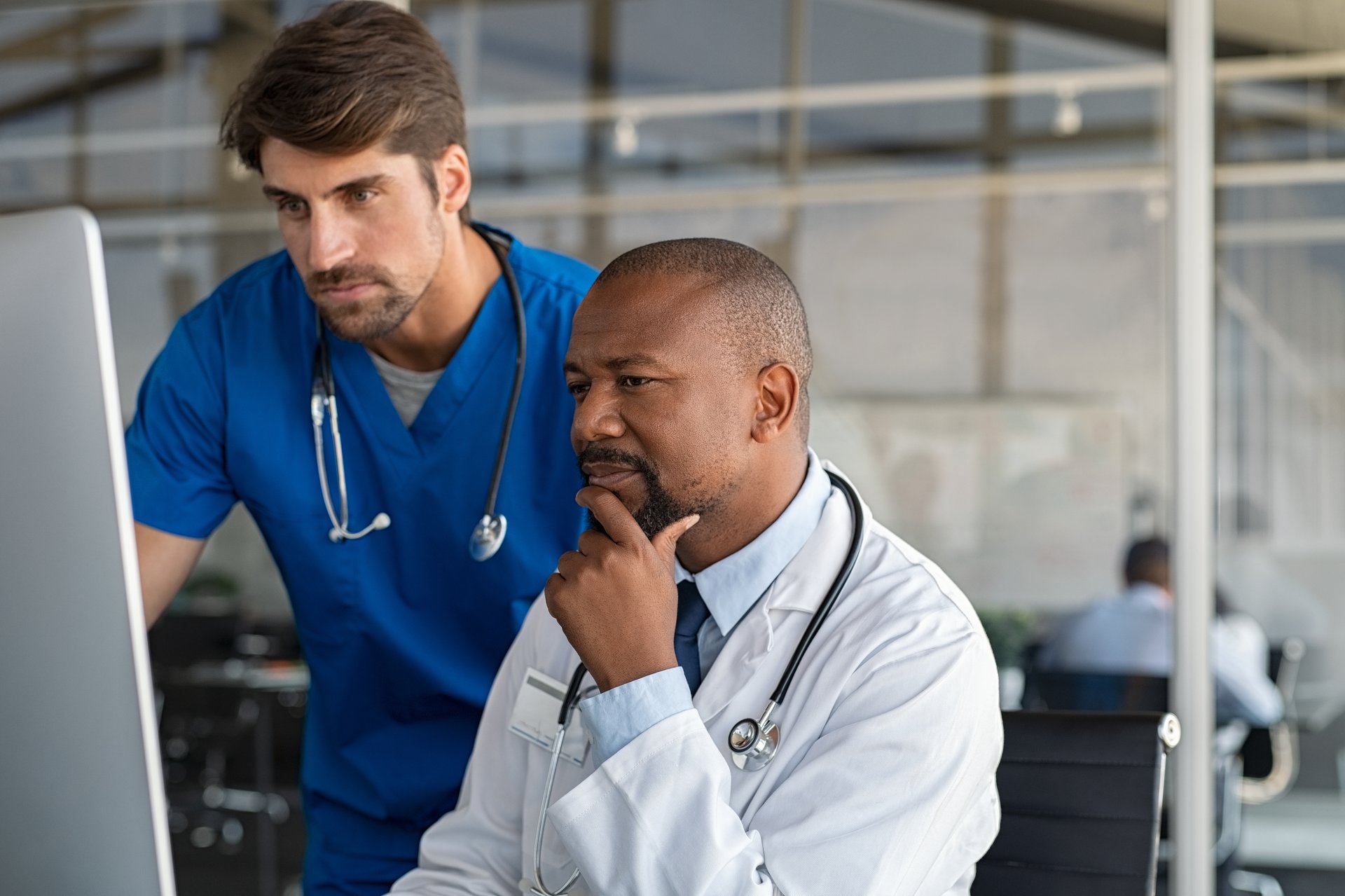 two male doctors looking at a computer screen