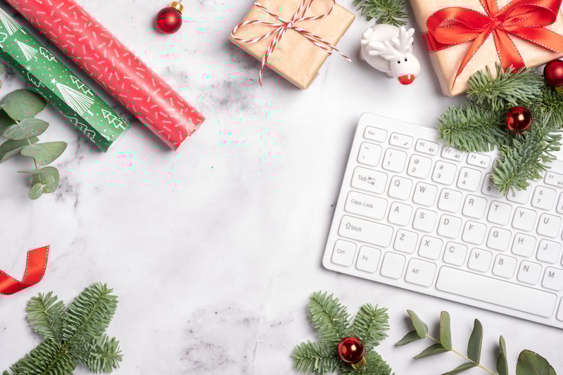 Office holiday gifts with ornaments, wrapping paper, and keyboard