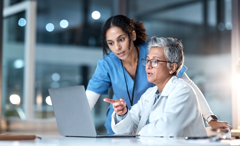 two healthcare professionals looking at computer screen