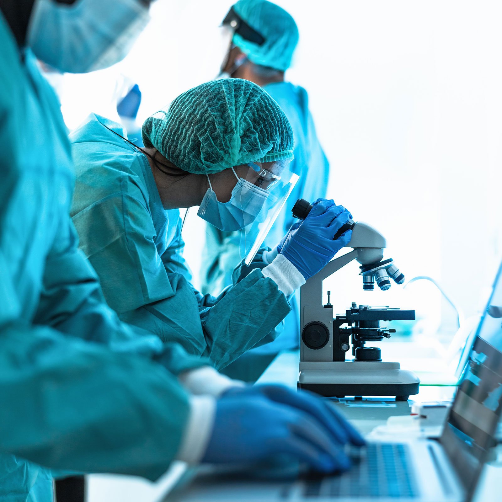 Doctors in lab wearing PPE looking at lab equipment