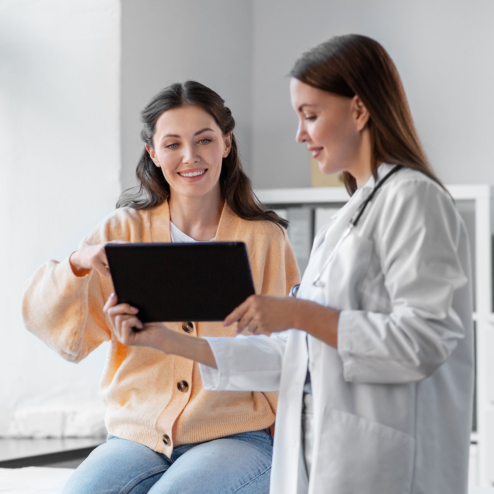 Doctor and patient reviewing data on tablet 