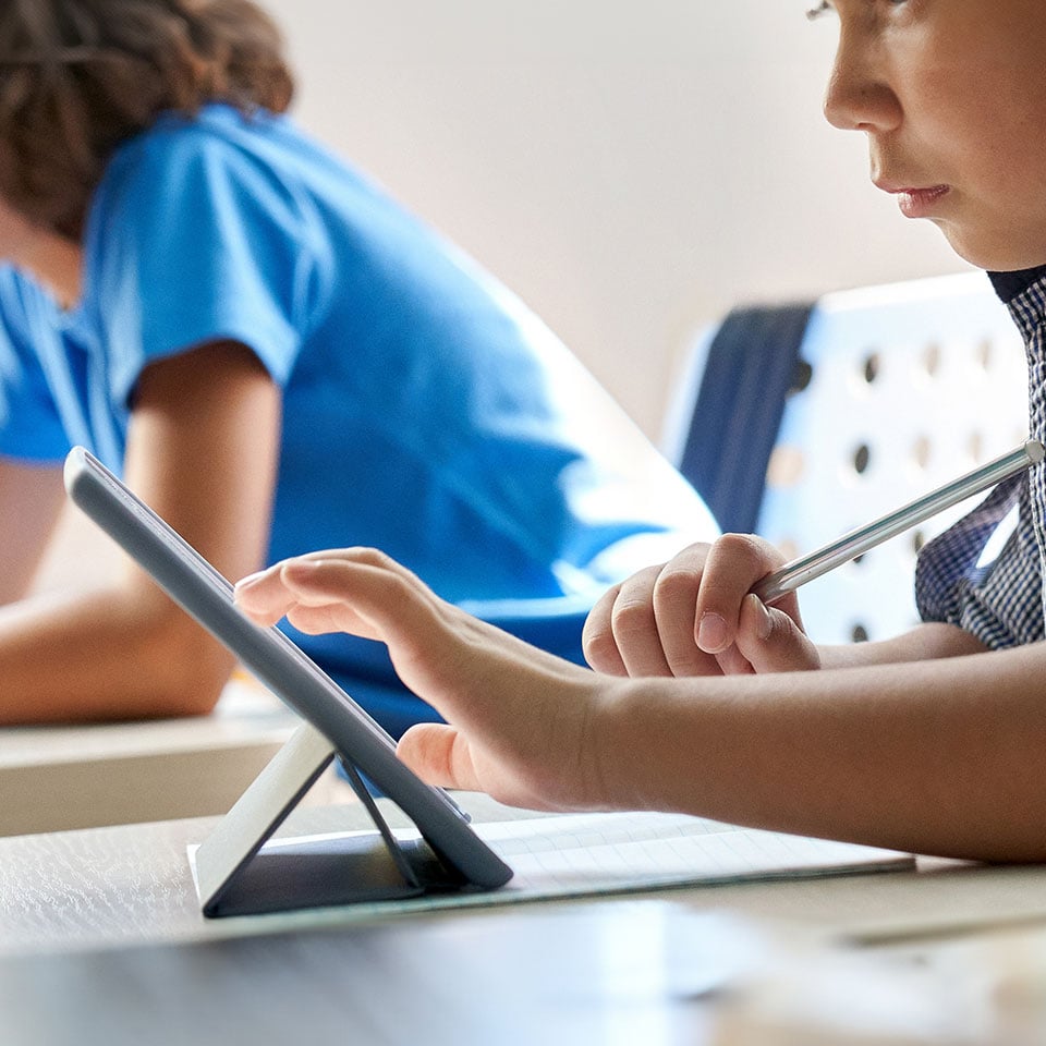 Students using tablets in a classroom setting, supported by managed IT services for enhanced digital learning