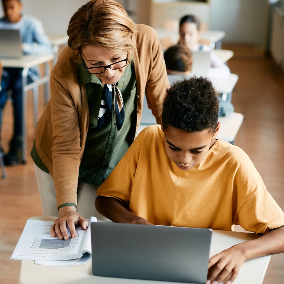 Teacher using digital whiteboard technology in a classroom, supported by education IT services