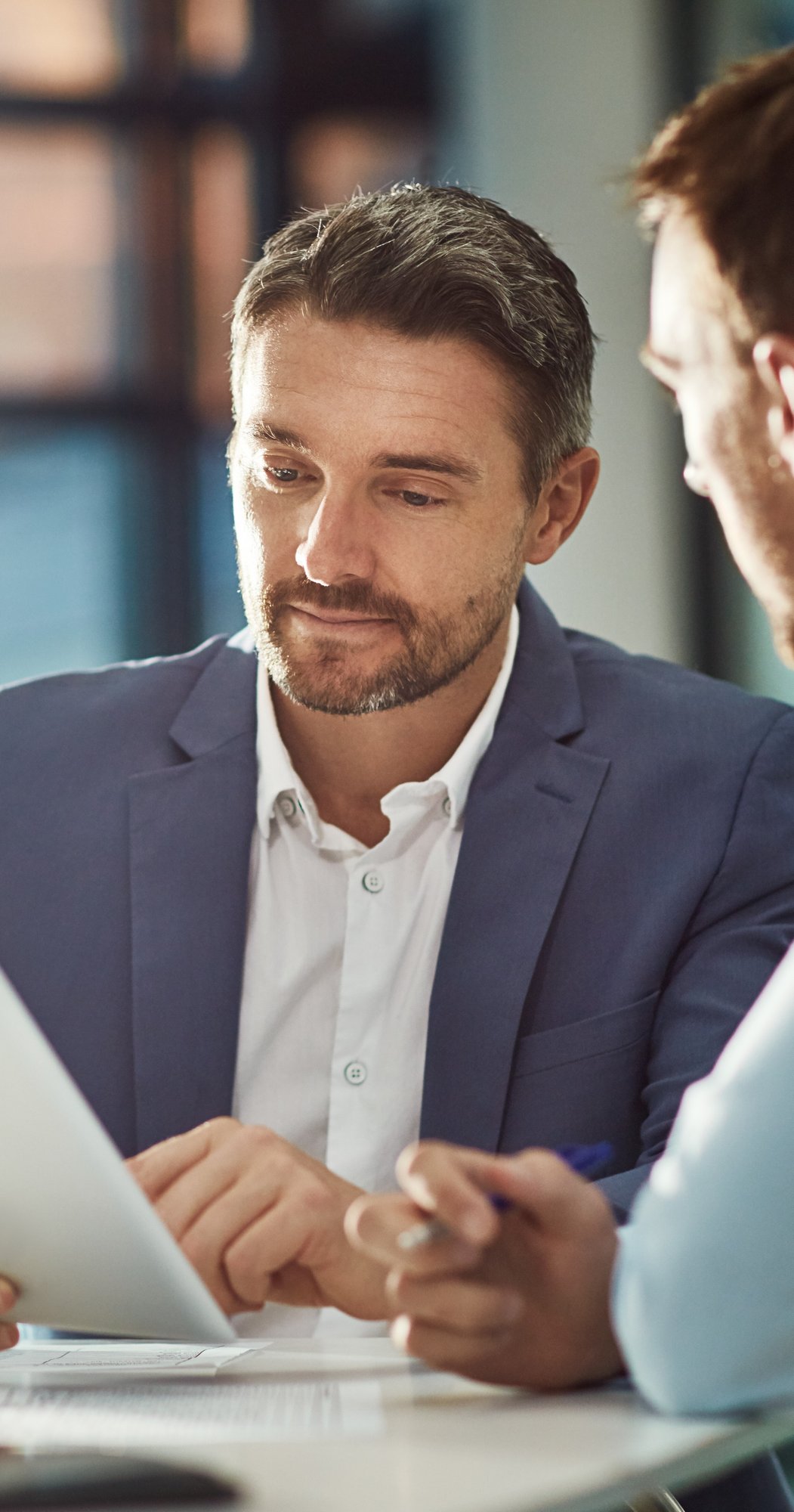 business man showing another business professional data on a tablet-1